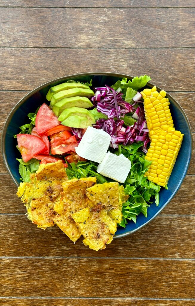 Vibrant salad bowl with avocado, corn, tomatoes, and more for a fresh meal.